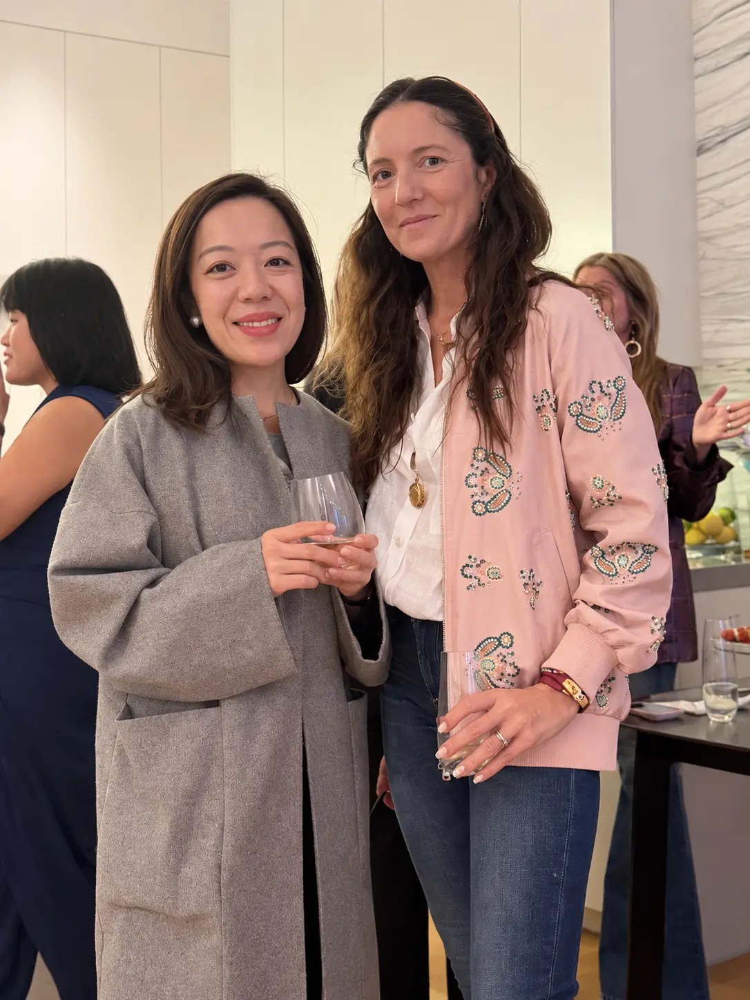 Two guests smiling with wine glasses
