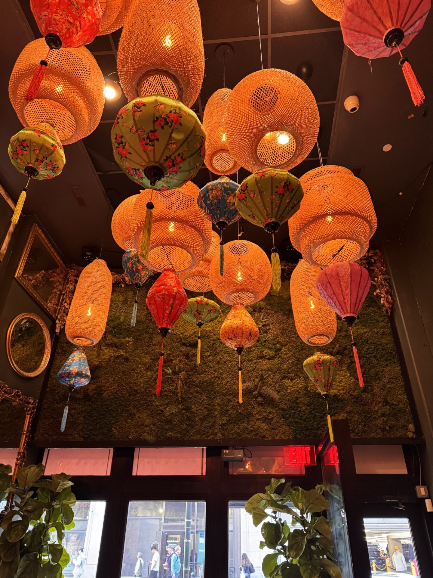Woven rattan and silk lanterns hanging above a moss wall at the Philadelphia venue