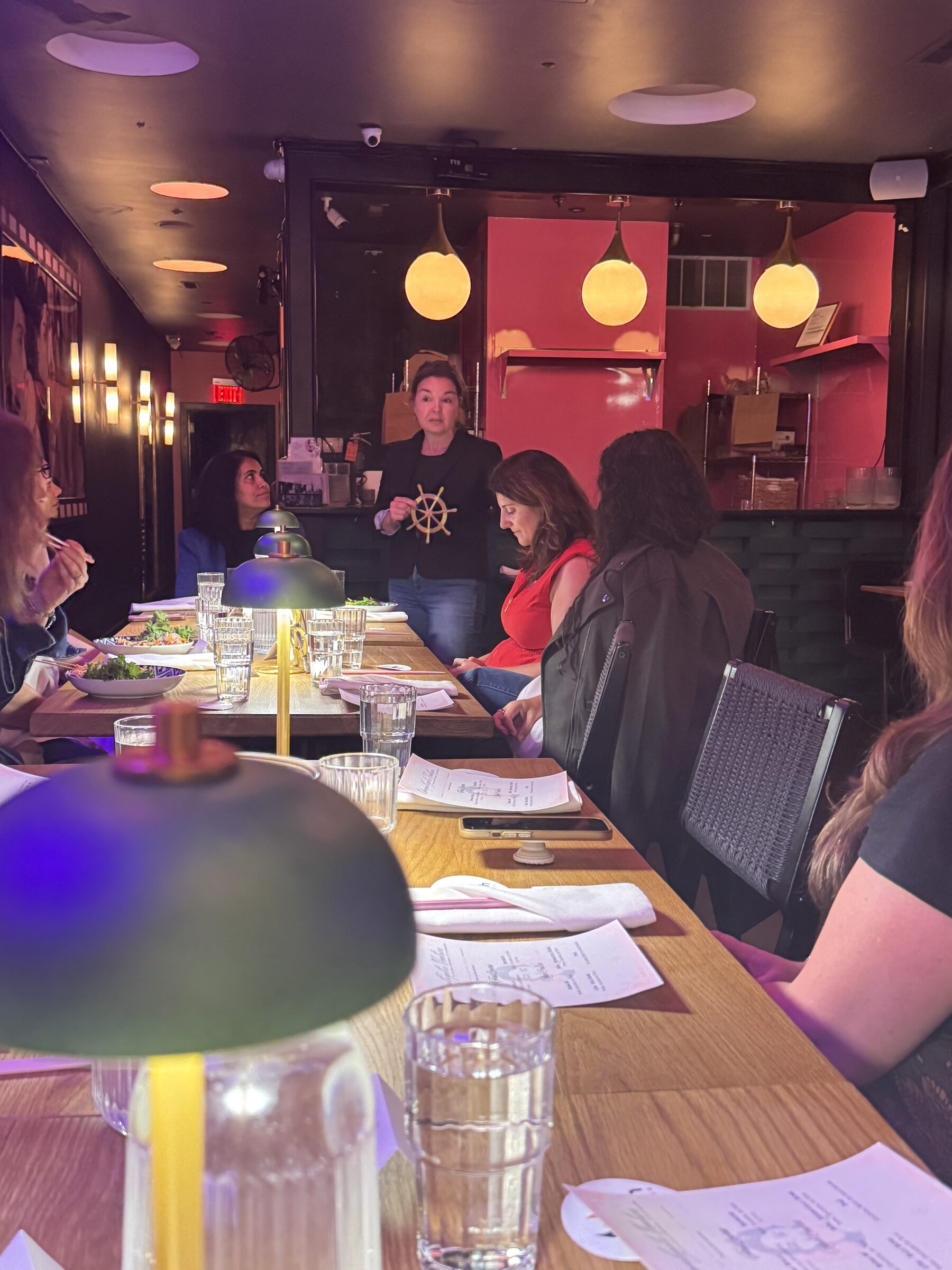 Guests seated along the long table as a speaker addresses the room at the Philadelphia gathering