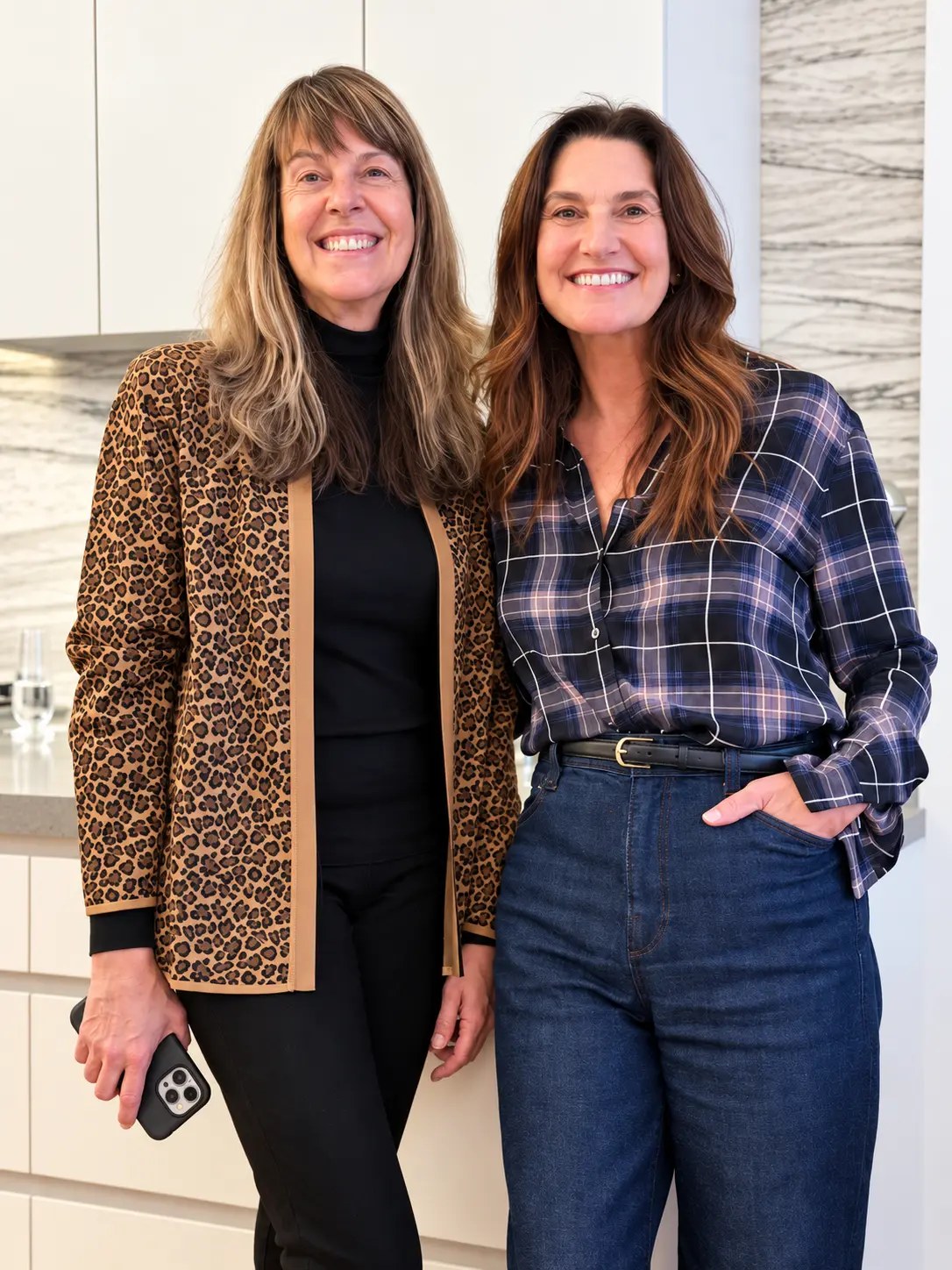 Two guests smiling by the kitchen counter