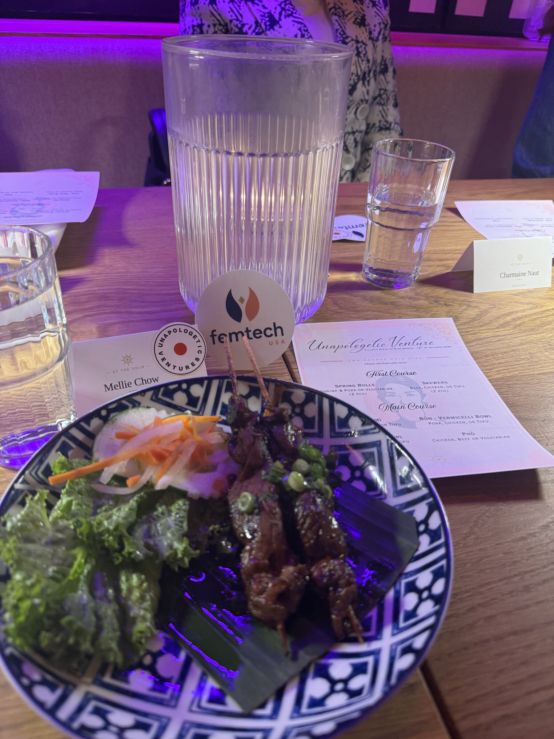 Plate of grilled skewers and fresh greens beside the printed menu and place cards at the Philadelphia dinner