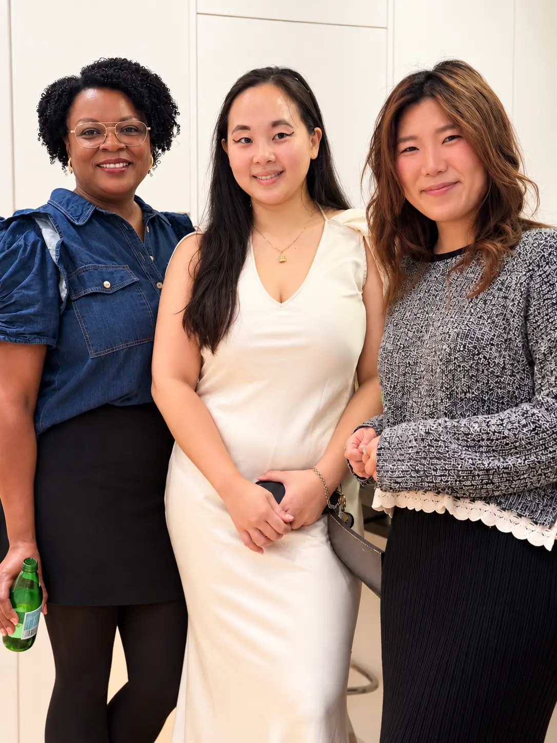 Three guests posing together in the kitchen
