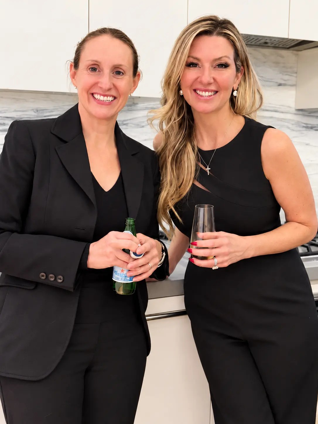 Two guests smiling with drinks in hand