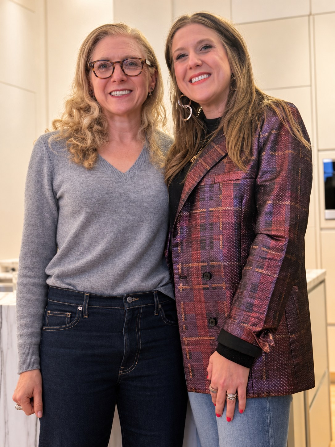 Two guests smiling together in the kitchen at Rosé at the Helm